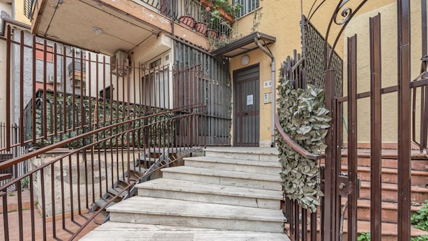 A set of stone steps leading to a door, surrounded by metal railings and a gate with foliage. - GuestHost - Cozy Studio x2 - w/ Balcony (Chianchitta)