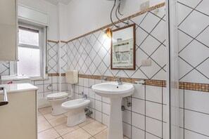 Een douche, een haardroger, een bidet, handdoeken