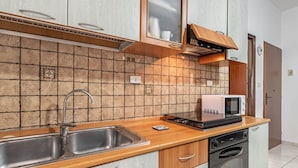 A kitchen with a double sink, a microwave, a dishwasher, and a tiled backsplash. - GuestHost - Cozy Studio x2 - w/ Balcony (Chianchitta)