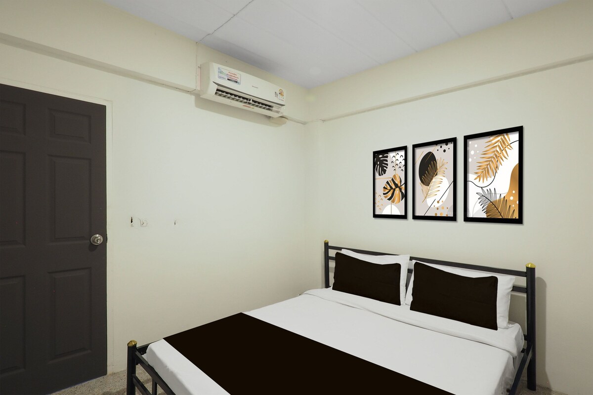 A bedroom with a bed, a door, and an air conditioning unit.