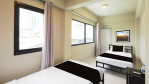 A hotel room with two beds, a desk, a chair, a window with curtains, and a picture on the wall. - RQ Bangkok Huai Khwang by Collection O (Bangkok)