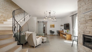 A spacious living area with a staircase, a fireplace, a dining area, and a kitchen. - Nature Villa Frangipane with Pool, Drivenik, Croatia (Drivenik)