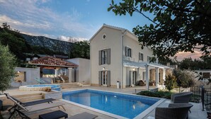 A two-story house with a swimming pool, outdoor furniture, and a patio area. - Nature Villa Frangipane with Pool, Drivenik, Croatia (Drivenik)