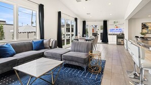 A modern living room with a sectional sofa, a coffee table, and a dining area with a bar. - 6 Bedrooms, 9 Beds, 3 Bathrooms, an 82° Heated Pool, & the BEST 102° Spillover Hot Tub in all of Old Town Scottsdale! (Scottsdale)