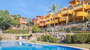 Ein Hotel mit Schwimmbad, mehreren Balkonen und einem angelegten Garten.