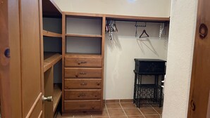 A compact room with a wooden wardrobe, a small black table, and a clothing rack. - Amorito Guest house, Pool, 1 block from beach, 6 blocks from downtown  (Loreto)