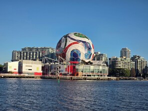 Un edificio frente al agua con una gran estructura esférica y colorida.
