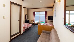Une chambre d’hôtel avec deux lits, un canapé, un bureau et une télévision.