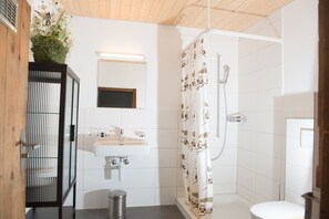 Een moderne badkamer met een witte wastafel, spiegel en douchegordijn met dierenprint.