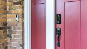 A red door with a keypad lock and a doorbell. - Hot Tub | Built in Fire Pit | Fenced Yard for Kids (Fargo)