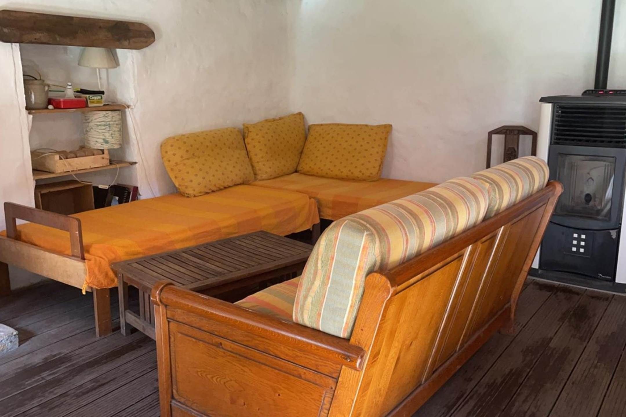 Een gezellige kamer met een houten bank, een kleine tafel en een open haard.