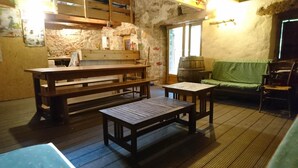 A rustic room with a wooden bench, a small table, and a green-covered sofa.
