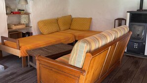 Ein gemütliches Zimmer mit einer Holzdirektiva, einem kleinen Holztisch und einem Kaminofen.