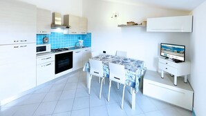Una cocina moderna con armarios blancos, una estufa a gas y un salpicadero de azulejos azules.