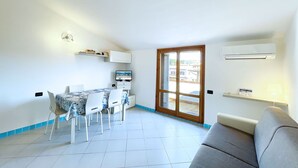 Un espacio habitable compacto con comedor, sofá y televisor.