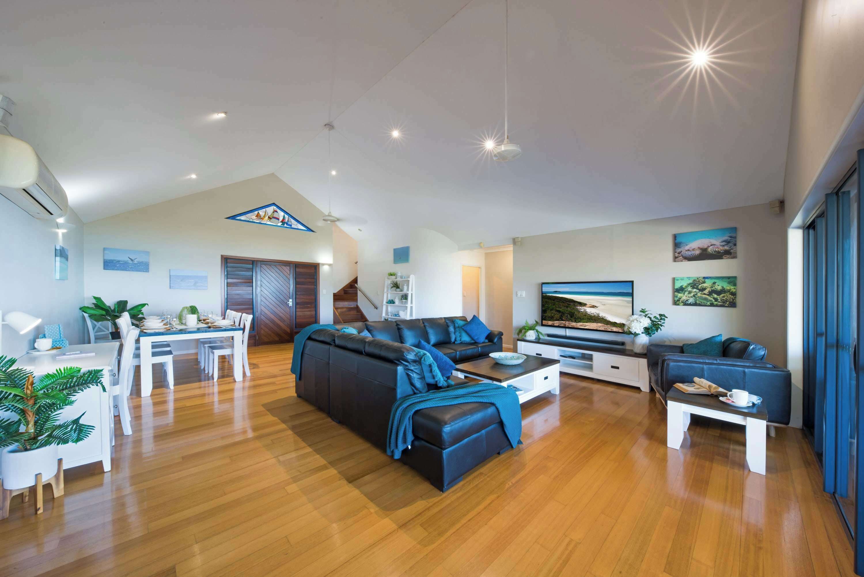 A modern living room with a sofa, coffee table, and dining area.