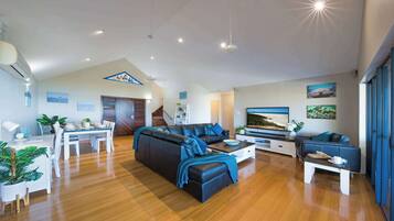 A modern living room with a sofa, coffee table, and dining area.