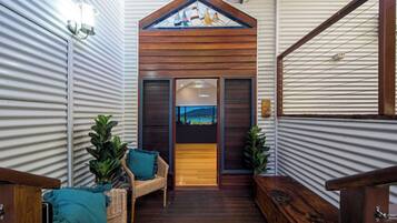 A narrow hallway with a wooden door leading to a room with a view.