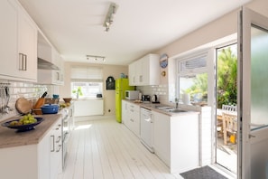 Bright fitted kitchen with dining area, self-catering holiday home sleeping eight in Rhosneigr, Anglesey