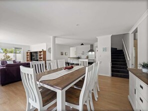 Un interno moderno con zona pranzo, cucina e soggiorno.