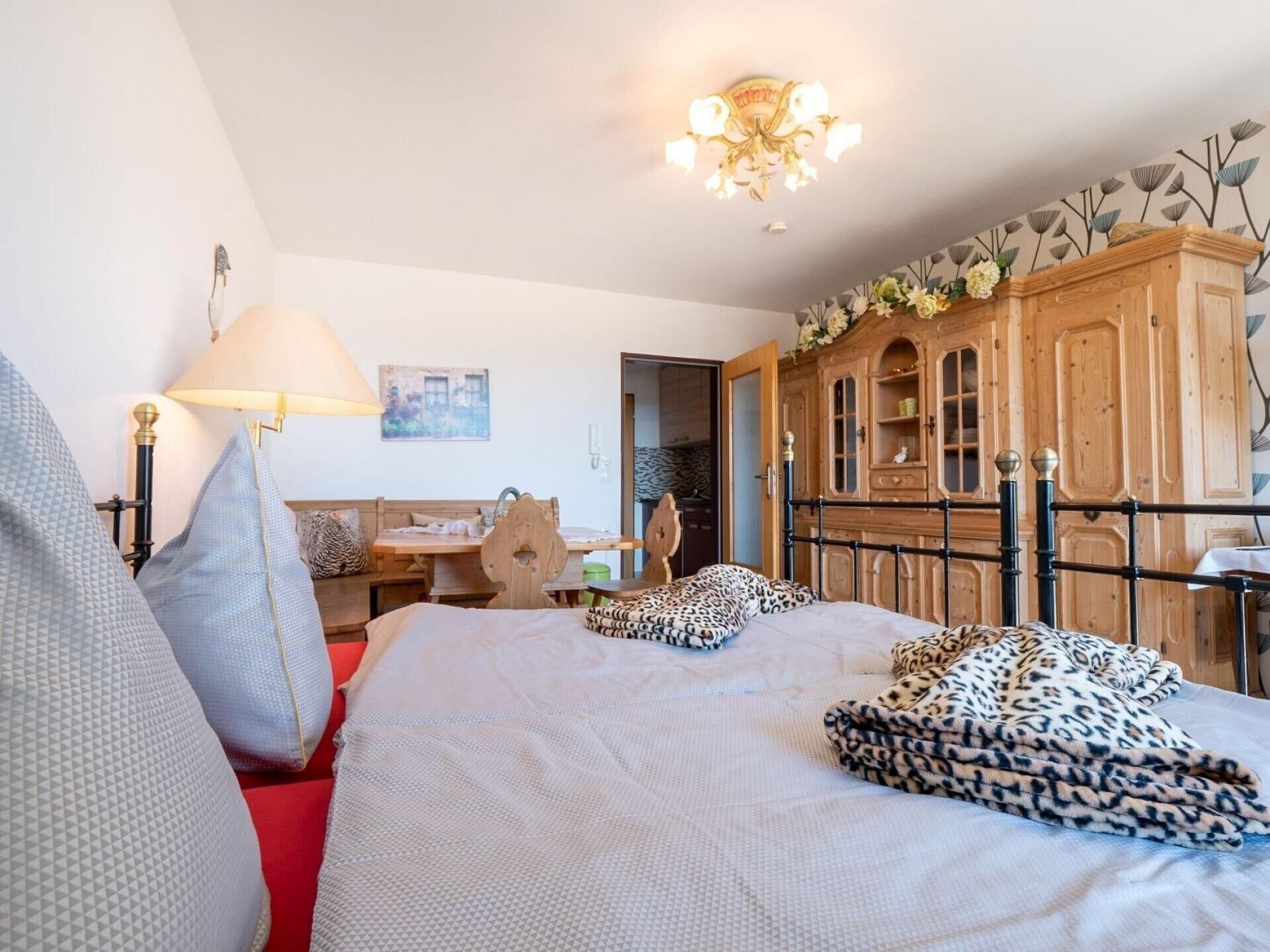 Ein Schlafzimmer mit einem Bett, einem Holzschrank, einem Schreibtisch und einem Stuhl.