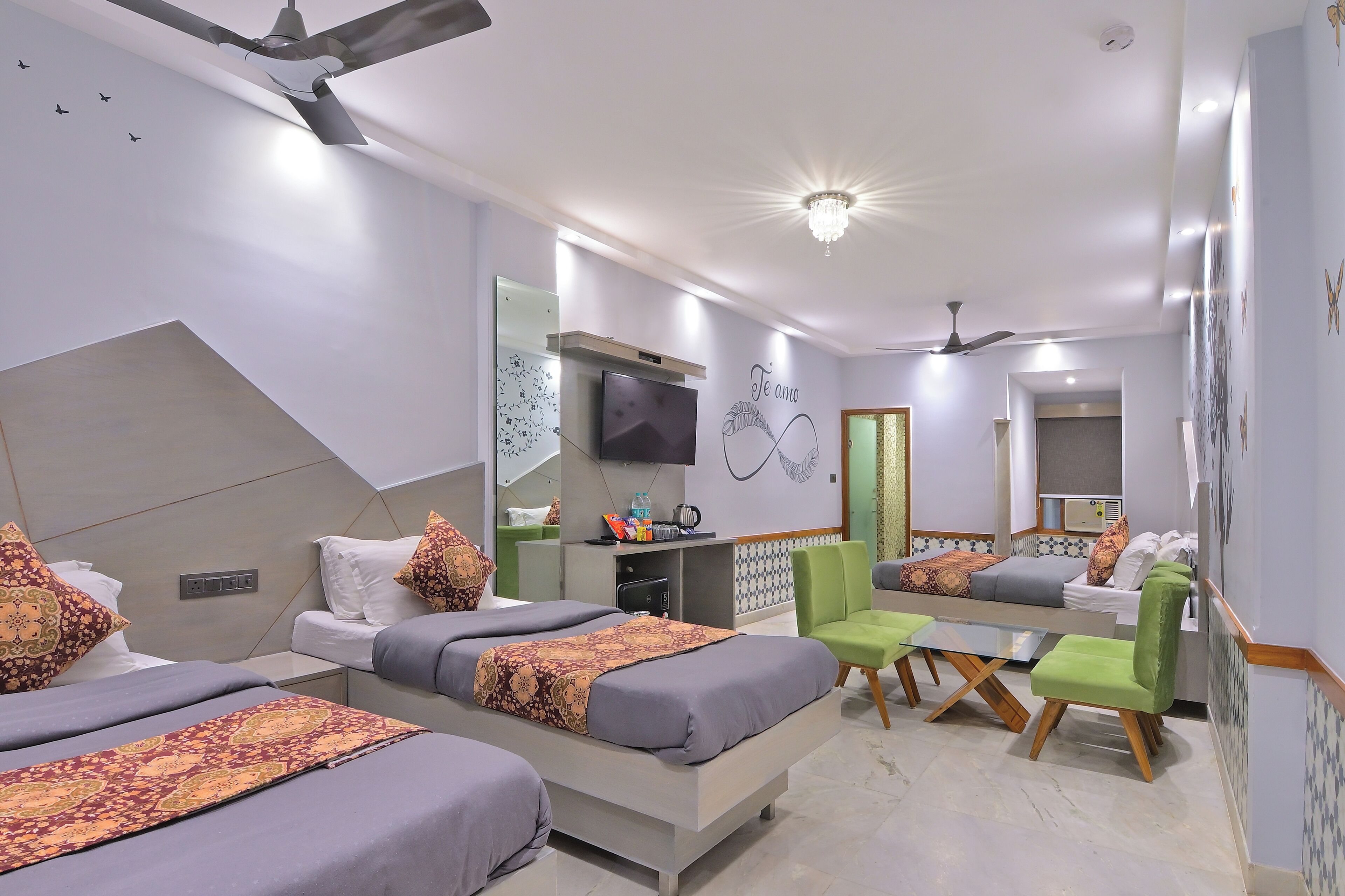 A modern hotel room with a large bed, a desk, and a seating area.