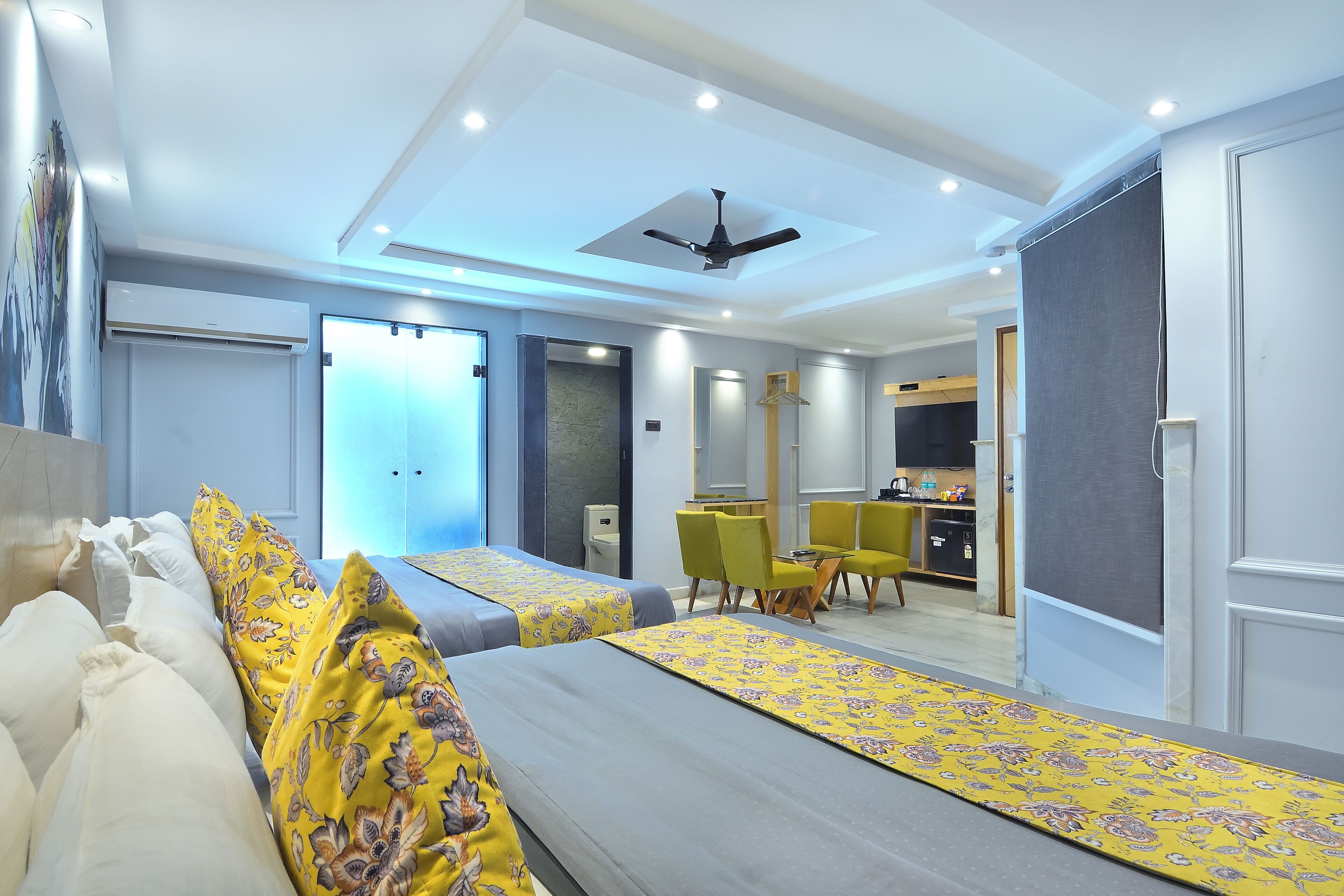 A hotel room with two beds, a dining area, and a kitchen.