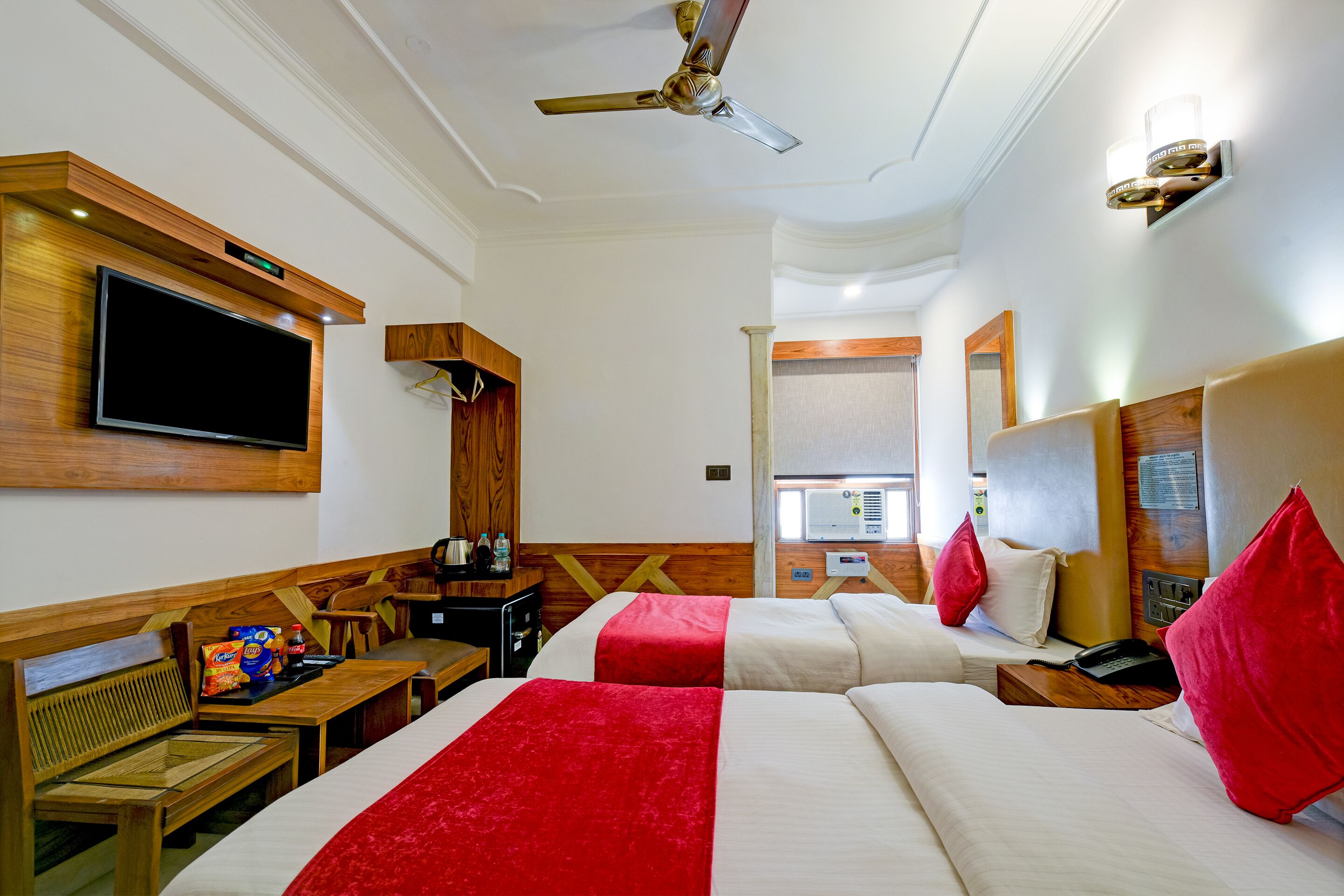 Habitación de hotel con dos camas, televisión, escritorio y silla.