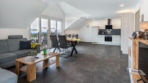 Un appartement moderne de style « loft » comprenant un coin repas, une cuisine et un espace de vie.
