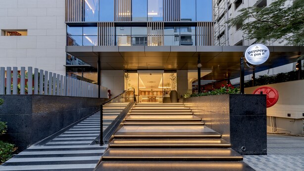Un bâtiment moderne avec un escalier menant à un restaurant appelé « Pepper Pot ».
