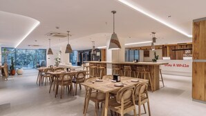 Un intérieur moderne avec des meubles en bois, des luminaires suspendus et un coin bar.