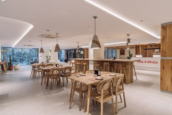 Un interior moderno con muebles de madera, iluminación colgante y una zona de bar.