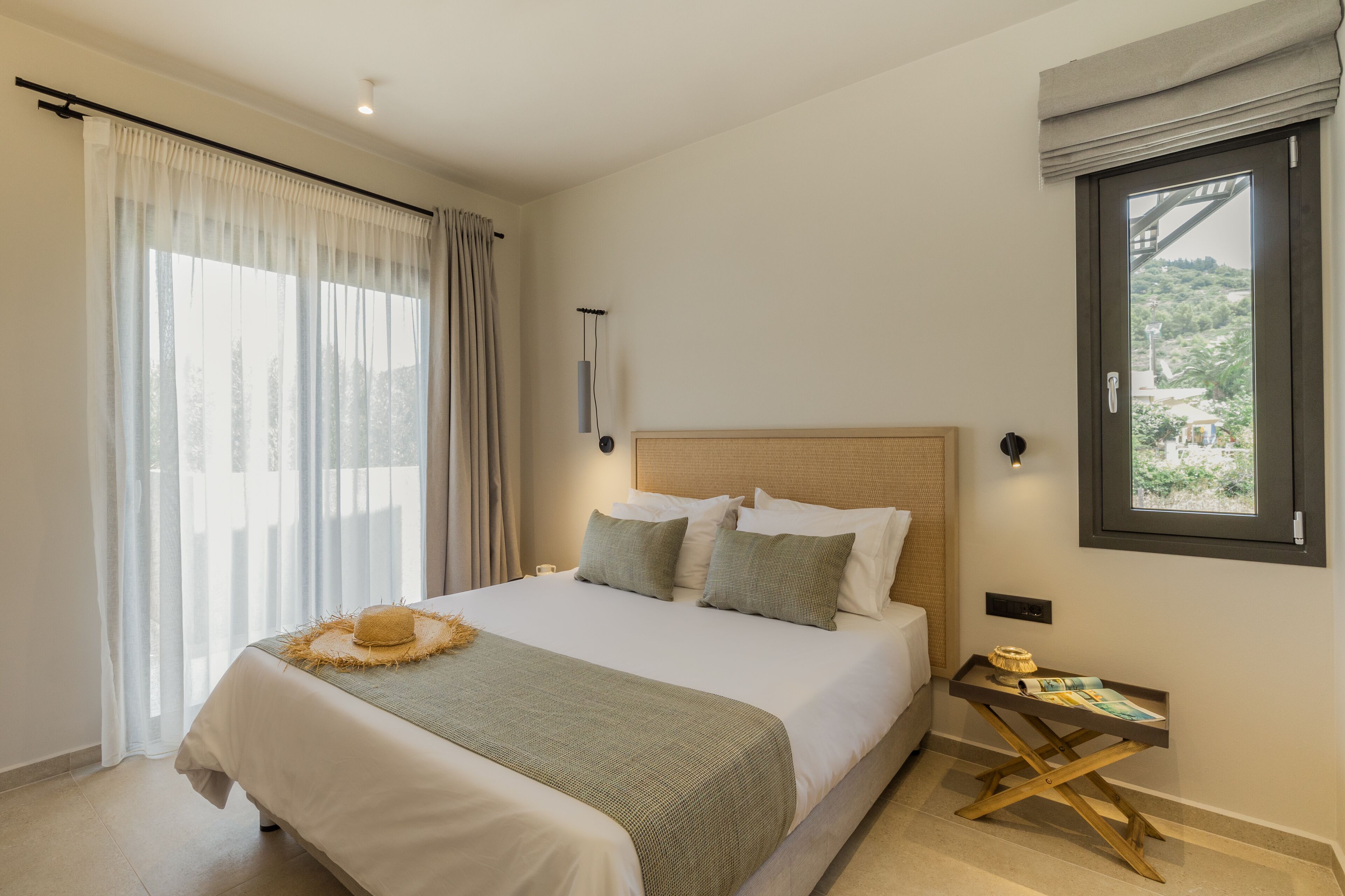 A neatly arranged bedroom with a bed, a bedside table, and a window.