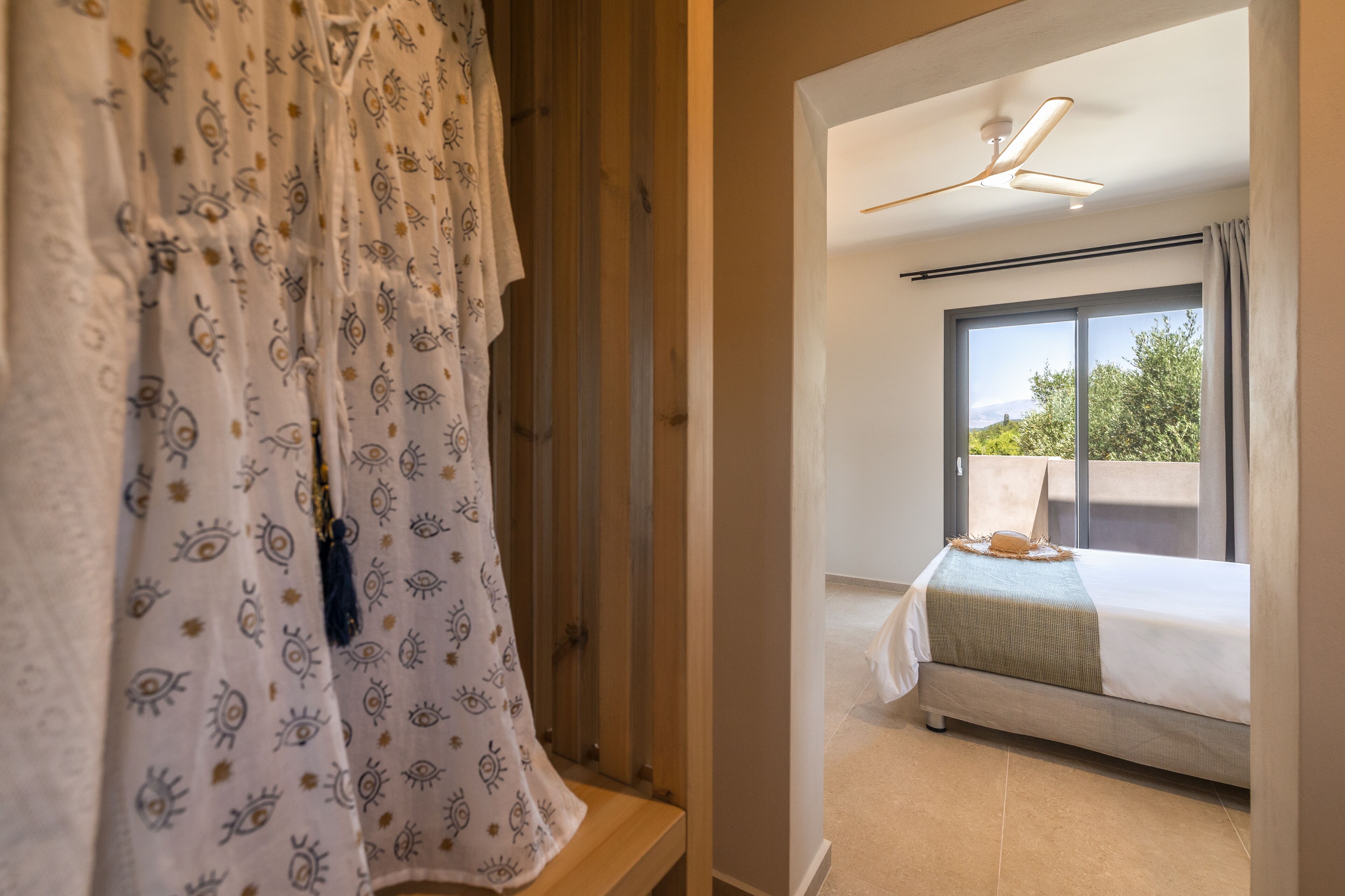 Une chambre à coucher avec un lit, une fenêtre et un ventilateur de plafond.