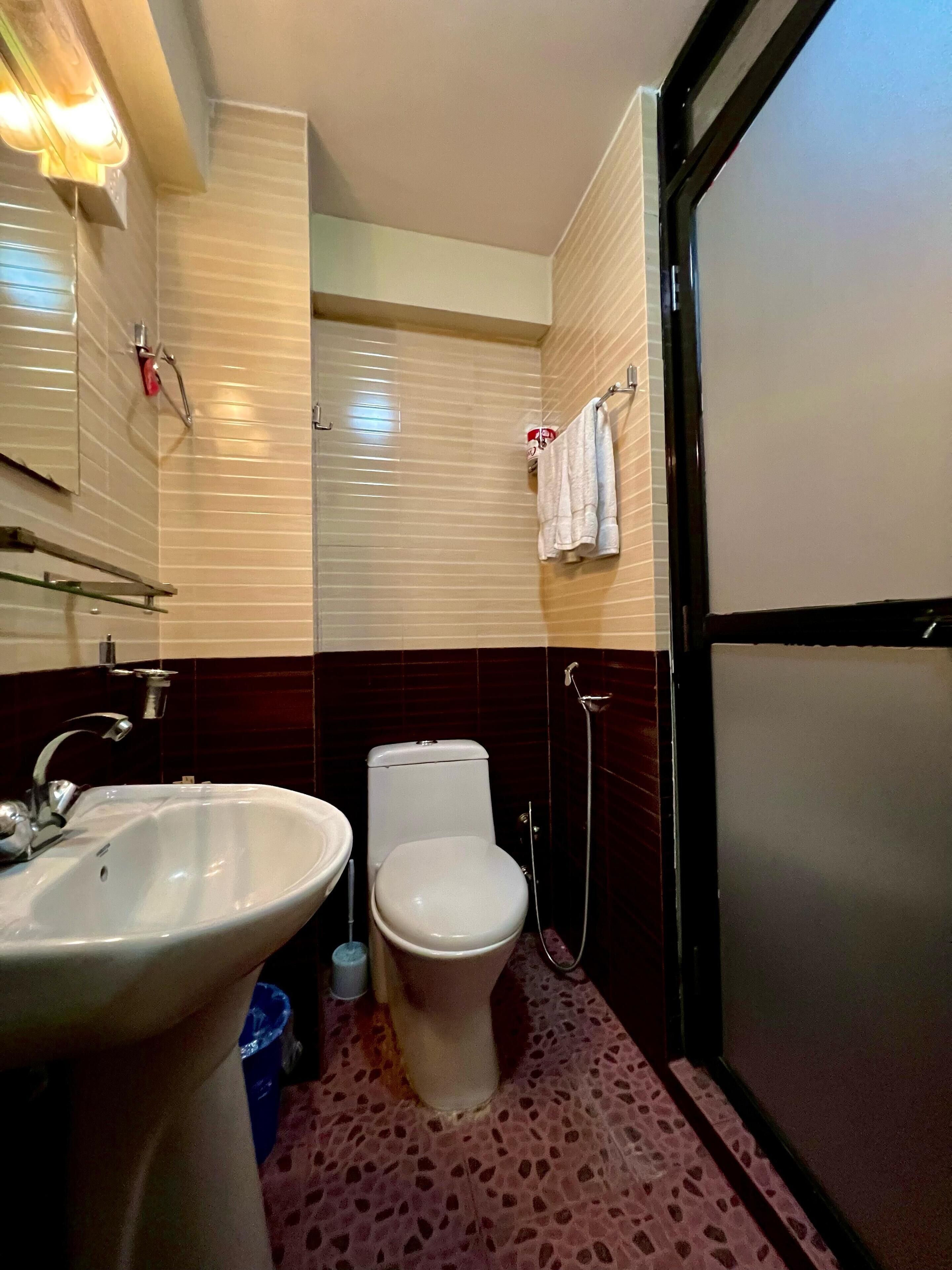 A bathroom with a sink, toilet, and shower.