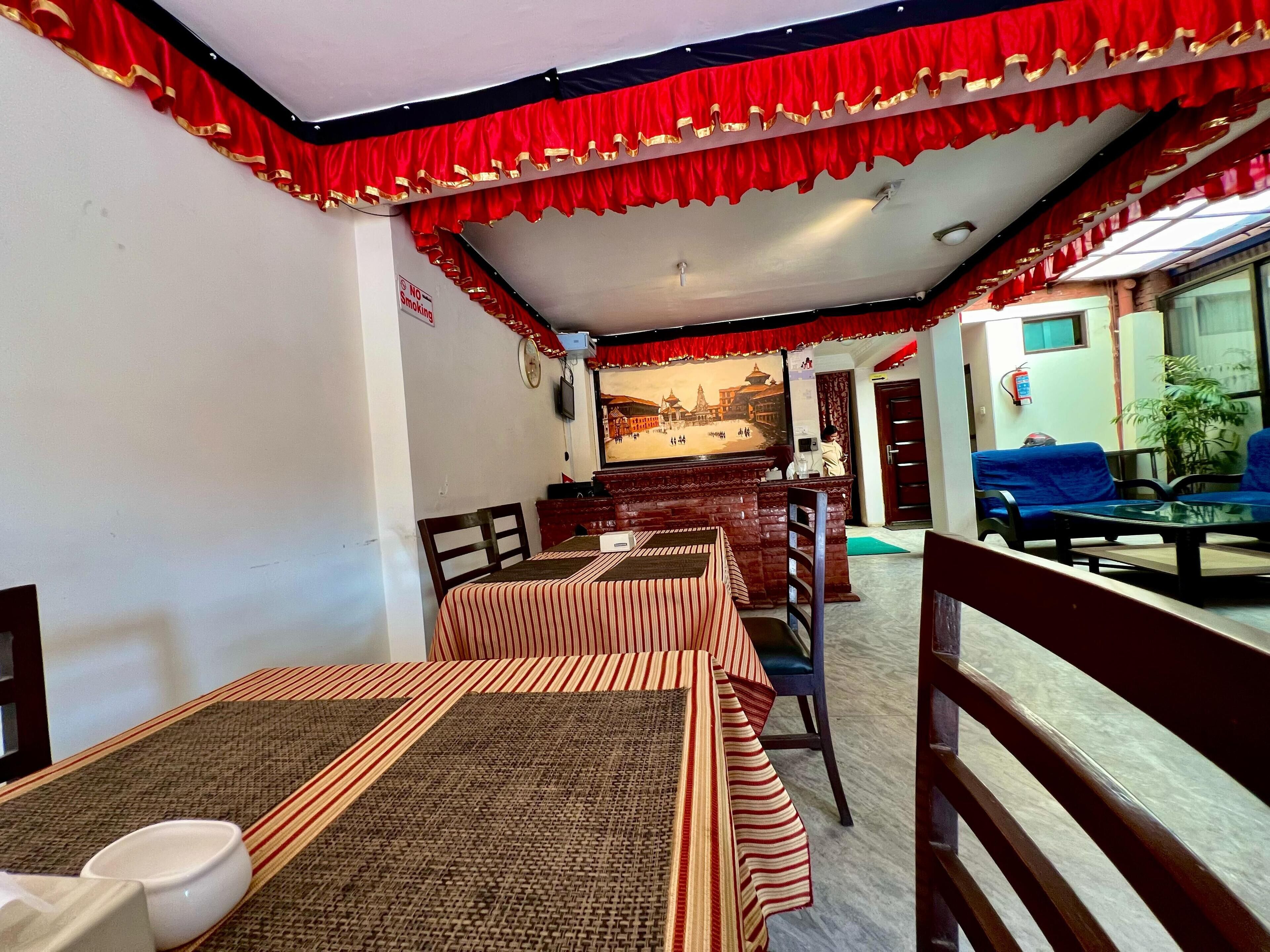 A dining area with striped tablecloths, a wooden counter, and blue upholstered seating.