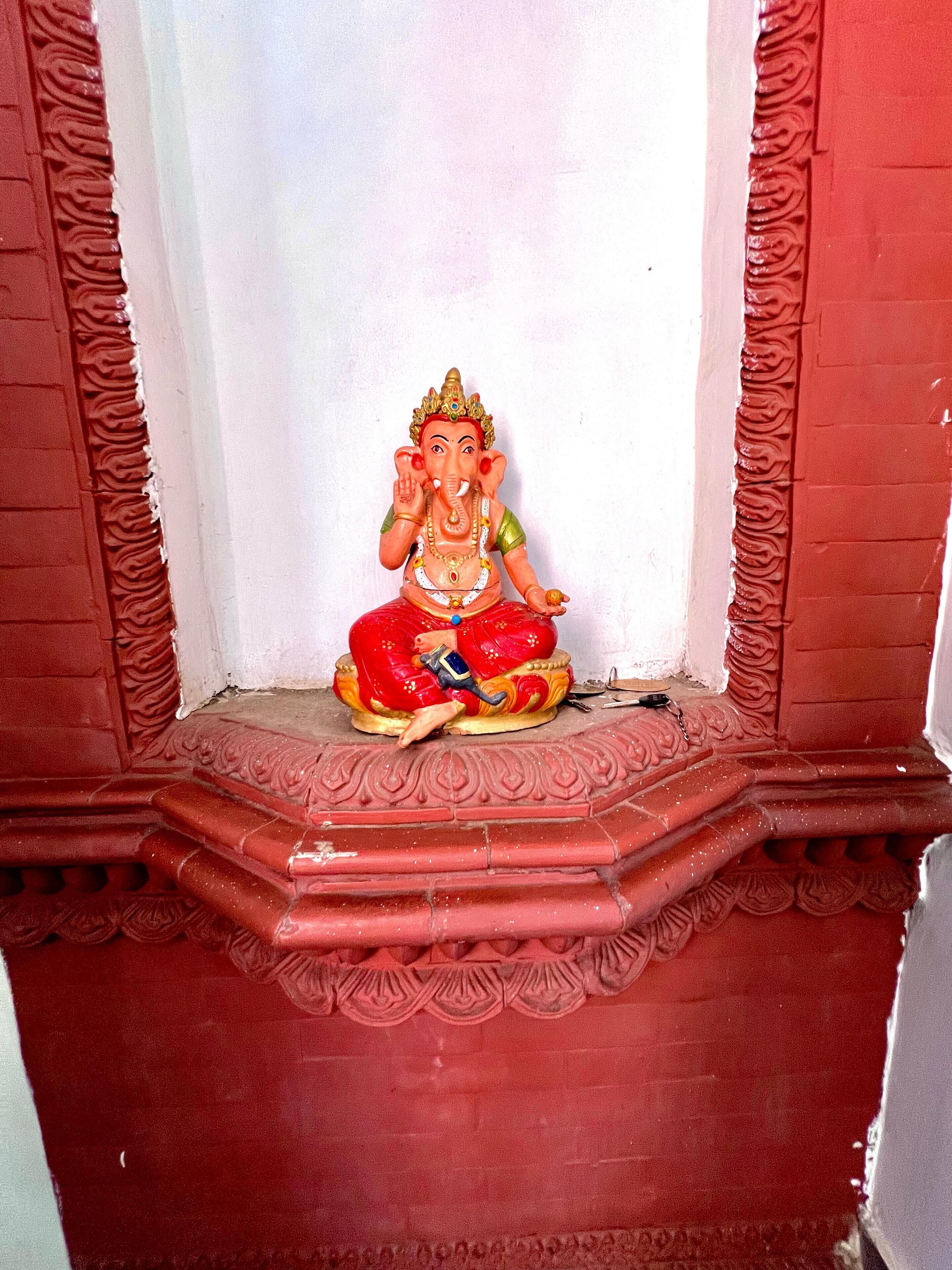 A statue of a deity in a niche with intricate carvings.