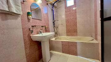 A bathroom with a sink, mirror, towel rack, shower, and bathtub.