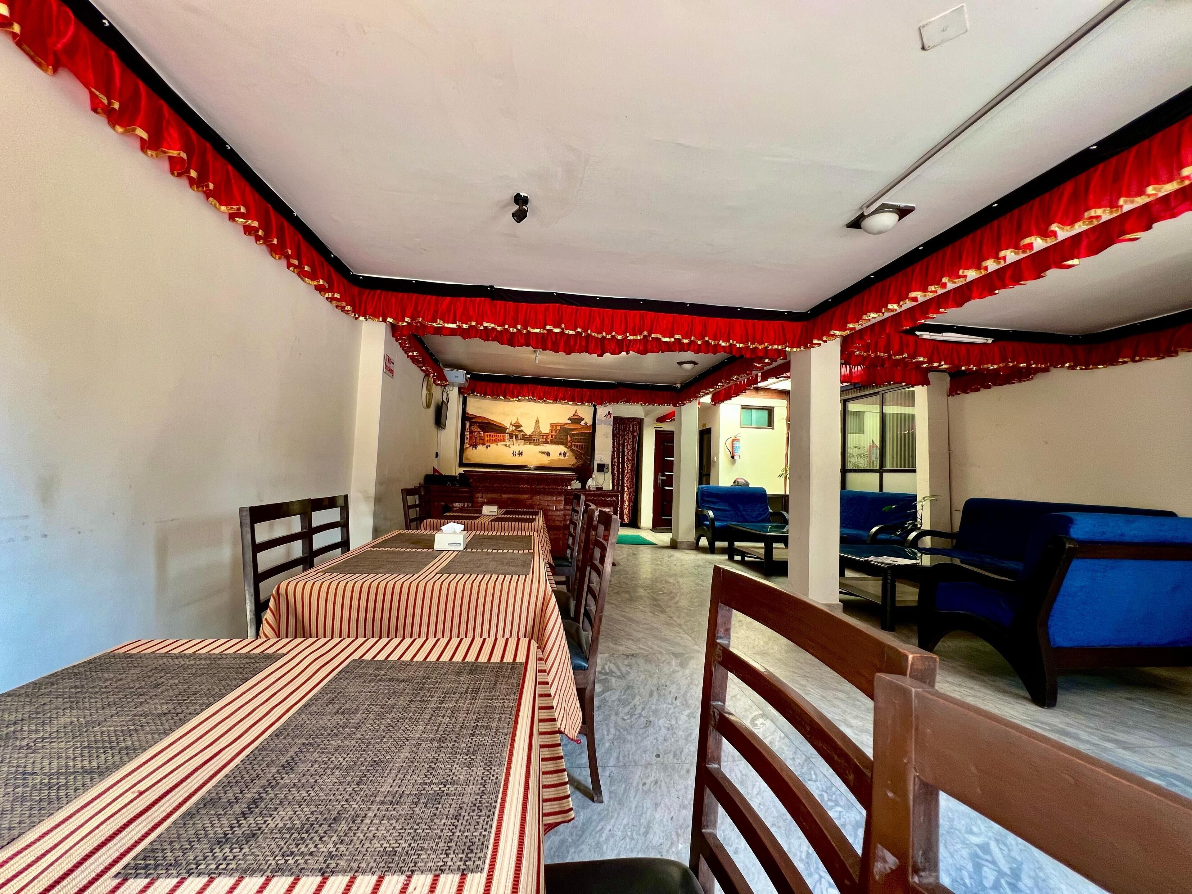 Quarto de hotel com área de refeições, uma janela grande e vista para um edifício.