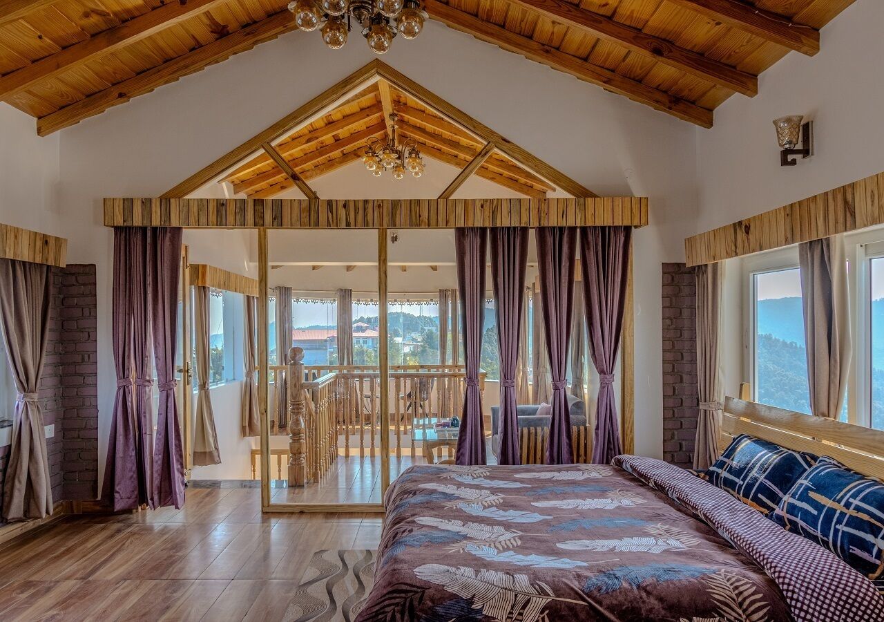 Un dormitorio con una cama grande, vigas de madera en el techo y un balcón con vistas.