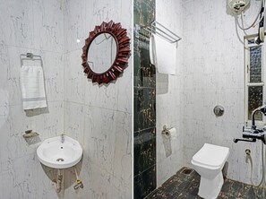 A bathroom with a white sink, a toilet, a mirror with a decorative frame, and a towel rack. - HOTEL VIRAJ (Pune)