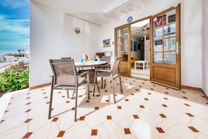 Contemporary room with a round table and chairs, a wall-mounted light fixture, and a geometric-patterned floor.