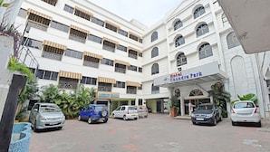 Un hotel con diversi piani, un cortile centrale e diverse auto parcheggiate.