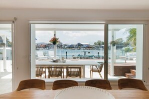 A dining area with a view of a marina and houses.