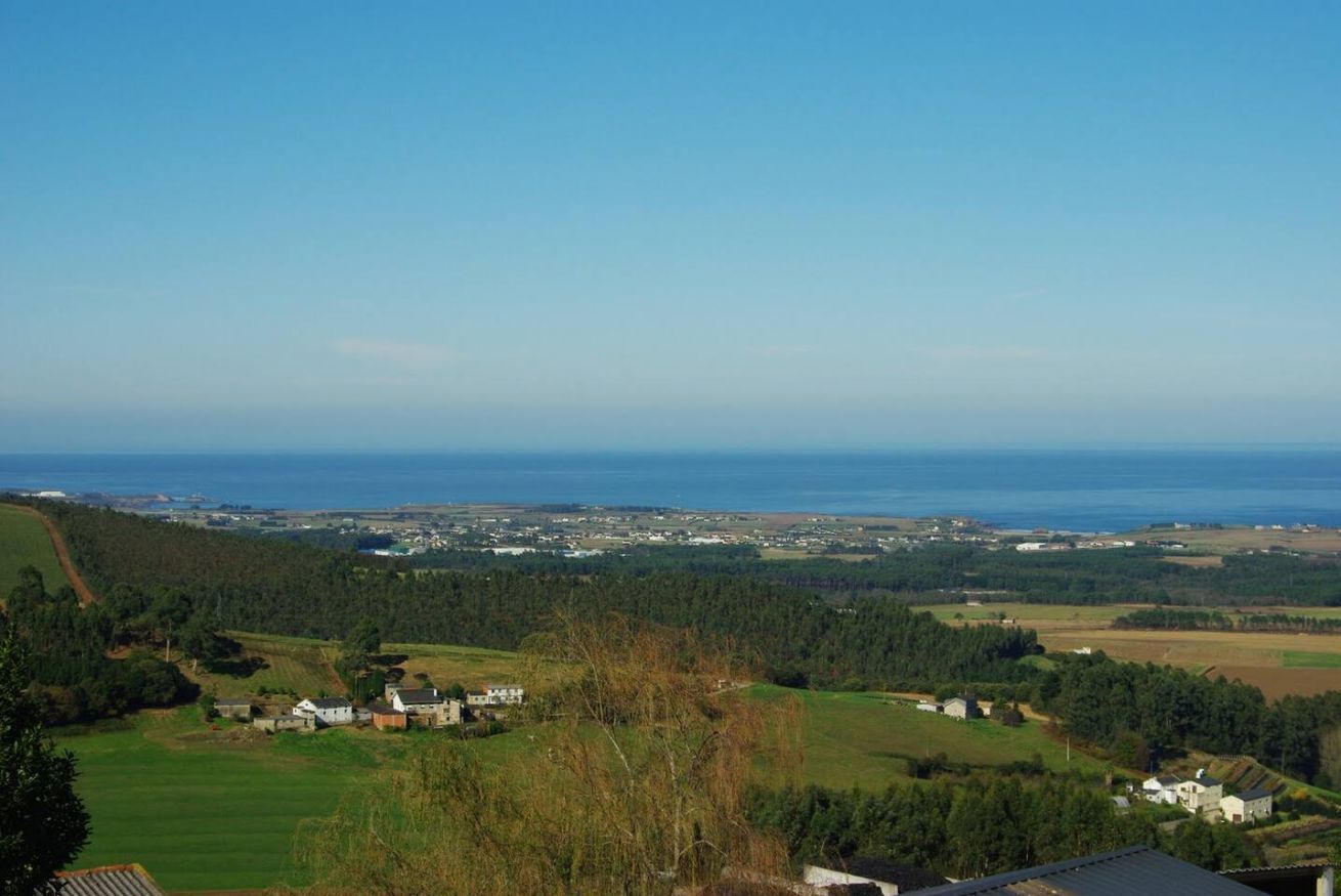 Eine Küstenlandschaft mit Häusern, einer Straße und Blick auf das Meer.