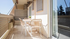 A balcony with a table and chairs, a potted plant, and a sliding glass door. - Upscale 3BR Apartment in Chalandri (Chalandri)