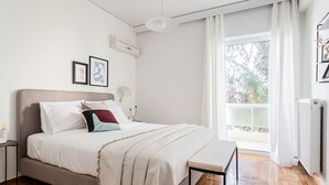 A bedroom with a bed, bedside tables, a window with curtains, and a radiator. - Upscale 3BR Apartment in Chalandri (Chalandri)