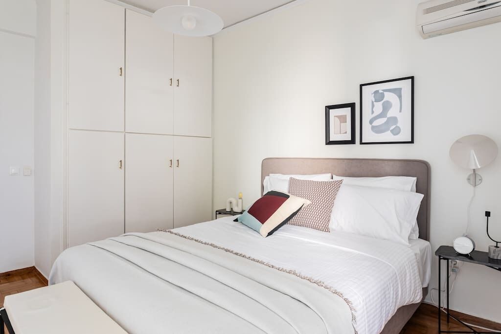 Ein ordentlich eingerichtetes Schlafzimmer mit Bett, Nachttisch und Kleiderschrank.