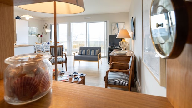Ein gemütliches Wohnzimmer mit Sofa, Sesseln, Couchtisch und Fernseher.