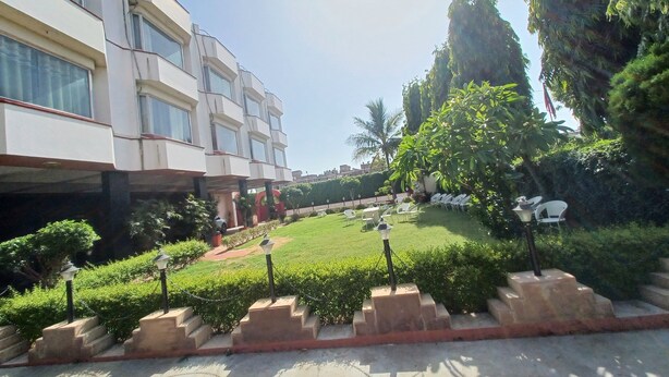 Il s’agit d’un bâtiment moderne, doté de plusieurs étages et de grandes fenêtres. Un jardin bien entretenu, avec de la pelouse, des arbustes et quelques arbres, s’y trouve.